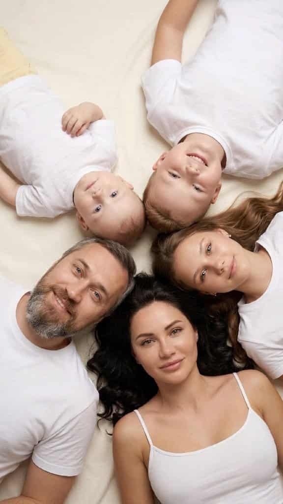 Visual Hook: Overhead view of four people and a baby lying in a star formation, heads t...