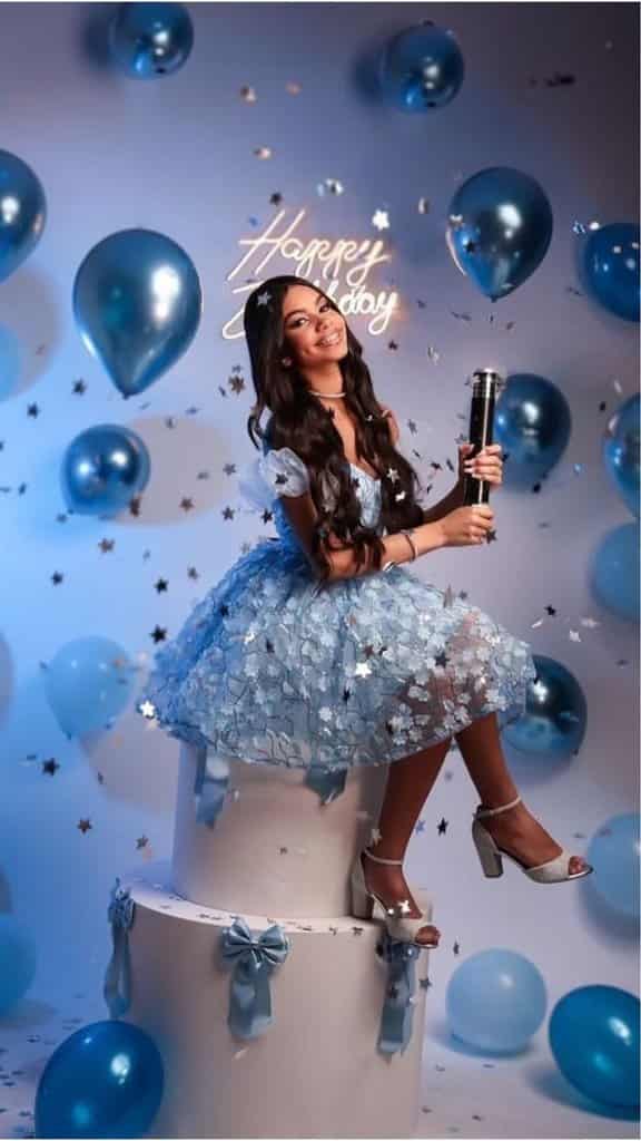 Visual Hook: A whimsical, celebratory portrait featuring a person in a voluminous blue...