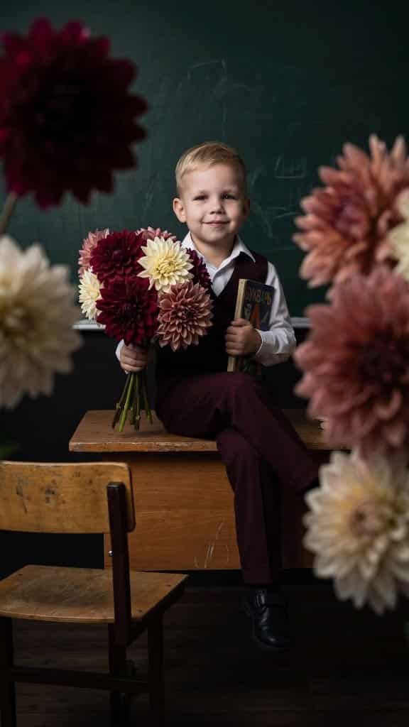 Visual Hook: A charming portrait of a child in school attire, framed by soft-focus dahl...