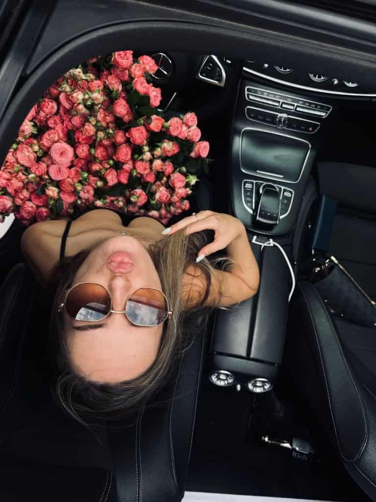 Visual Hook: An overhead, intimate view of a person reclining in a luxury car, framed b...