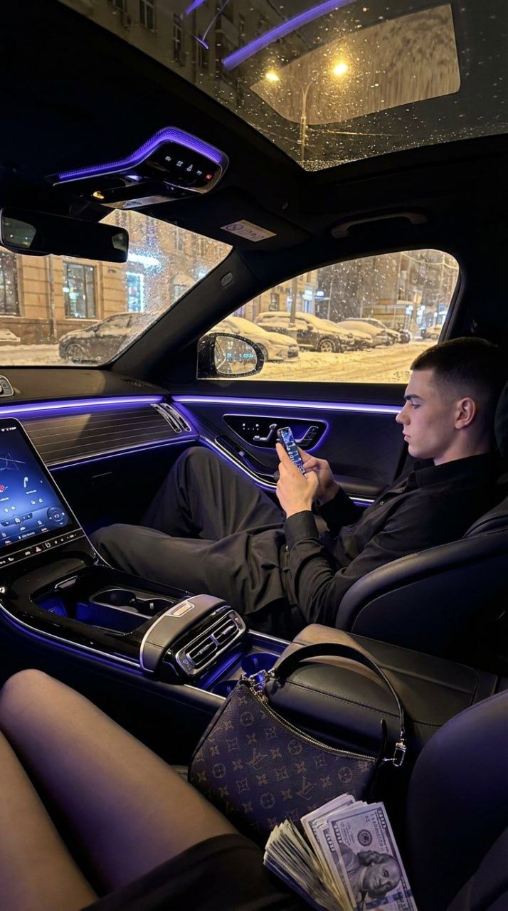 Молодой мужчина в черной рубашке за рулём Mercedes S class 63 2025 в зимнем ночном городе